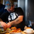 man standing beside table while holding food