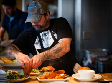 man standing beside table while holding food