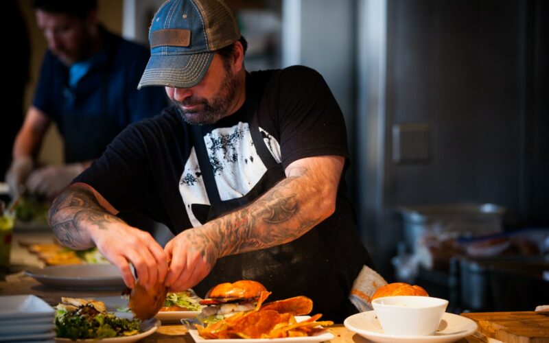 man standing beside table while holding food