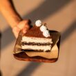 a person holding a piece of cake on a plate