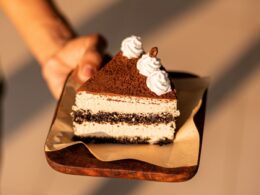 a person holding a piece of cake on a plate