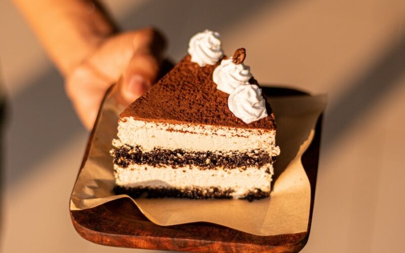 a person holding a piece of cake on a plate