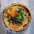 pizza with green leaf vegetable on white ceramic plate