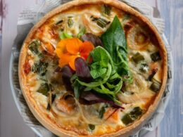 pizza with green leaf vegetable on white ceramic plate