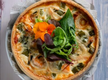 pizza with green leaf vegetable on white ceramic plate