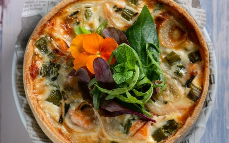 pizza with green leaf vegetable on white ceramic plate