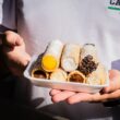 person holding white plastic container with bread